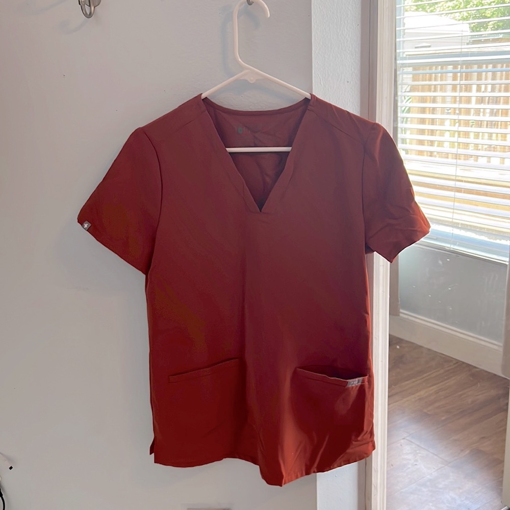 Figs sized small scrub top with pockets. Like new condition. Auburn-colored